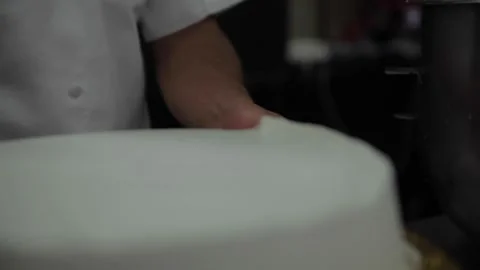 A baker uses a spatula to smooth a wedding cake Stock Footage 231414588