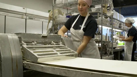 Baker using a dough sheeter Stock Footage 77080171