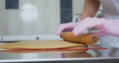 Baker is using a rolling pin to roll out the gingerbread dough, 4k Stock Footage 151820607