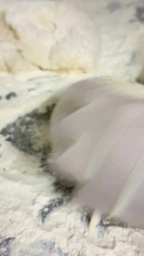 Baker wearing gloves kneading dough on a floured table Stock Footage 331982124