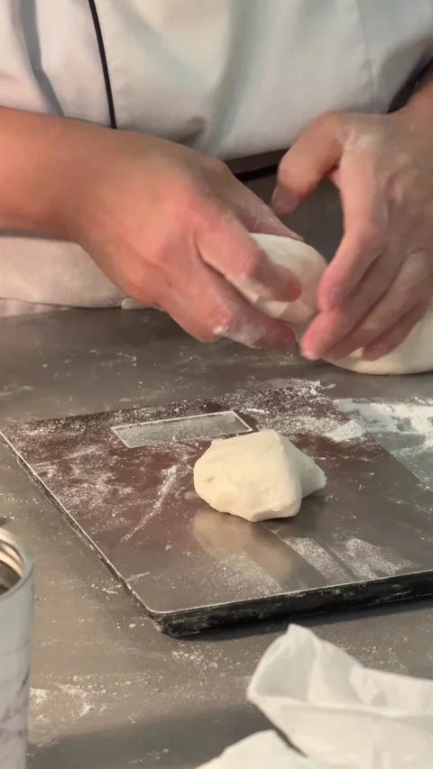 Baker weighing and portioning fresh dough on metal scale close up Stock Footage 335265443