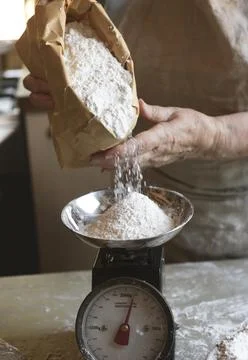 Baker weighing flour on a scale Stock Photos
