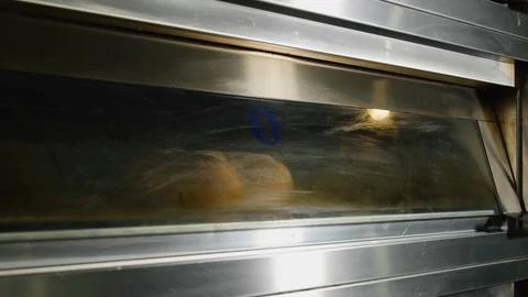 A baker who takes out the bread from the oven 4k Stock Footage 86893309