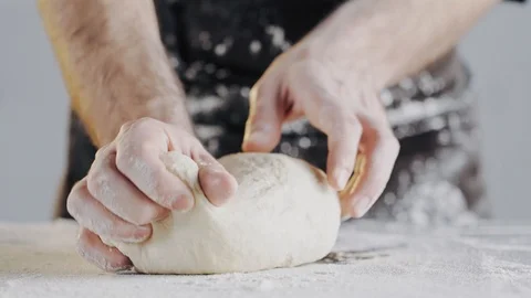 Baker working with dough. Clapping hands with flour, folding dough. Stock Footage 104720163