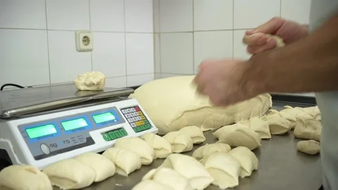 Baker working fast weghing pieces of dough with an electronic balance 스톡 동영상 251370631