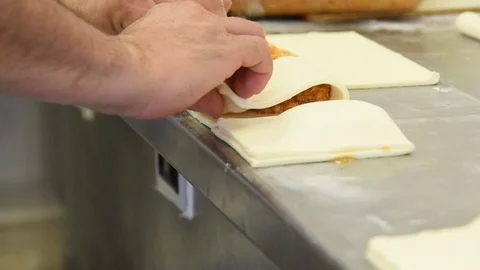 Baker working on stuffed patties also known as pastel, pate or pirozhki Stock Footage 117868931
