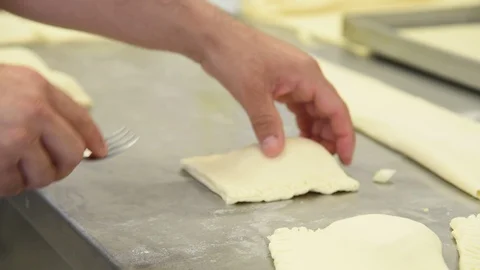 Baker working on stuffed patties also known as pastel, pate or pirozhki Stock Footage 117868961