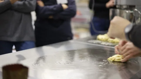 Baker works with dough surrounded by students Video stock 121036456