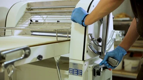 Baker works on floor Dough sheeter in bakery Video stock 106482769