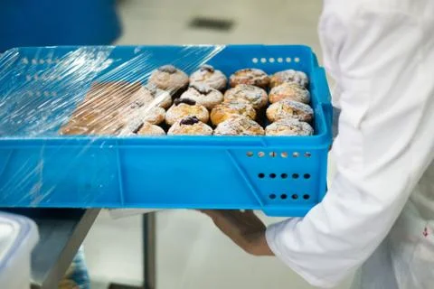 Baker Wrapping Tray of Muffins Stock-Fotos