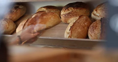 Bakeress packing a sourdough bread for costumer Stock Footage 197387492