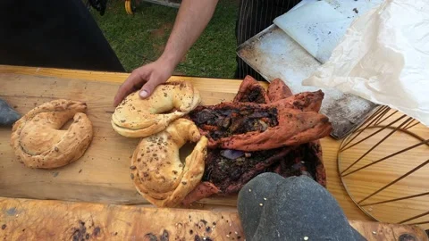 Baker's hand puts fresh crispy delicious bread from baking sheet in table. Stock Footage 199034933