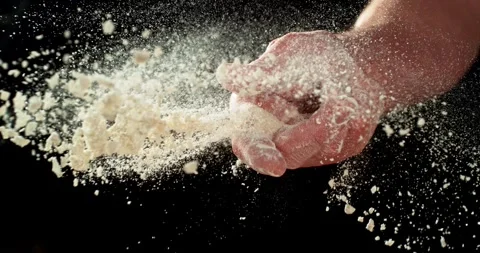 Baker’s hand tossing flour over prepared risen dough on wooden table. Stock Footage 328706491