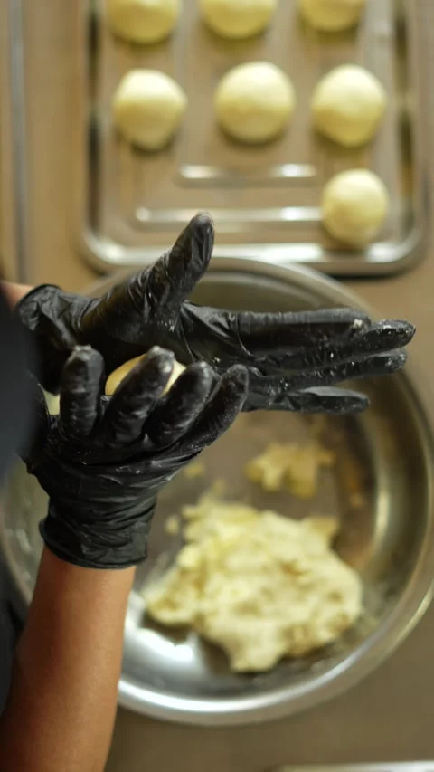 Baker's Hands Arranging Cheese Bread or Bunuelos on a Tray Stock Footage 285862381