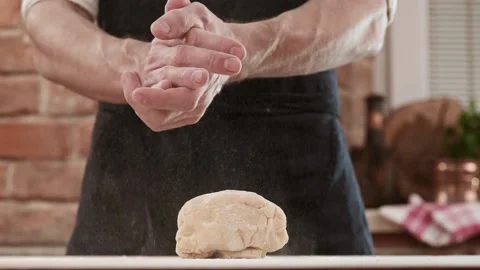Bakers hands clap their hands filled with flour on a black background. The baker Vídeos de archivo 150779141