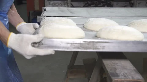 Bakers load bread dough into oven. slow motion Stock-Footage 100737747