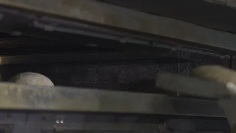 Bakers load bread dough into oven Stockbeeldmateriaal 100737782