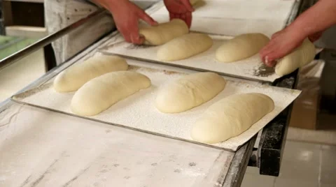 Bakers putting the raw bread to the baking sheet. Stock Footage 64471027