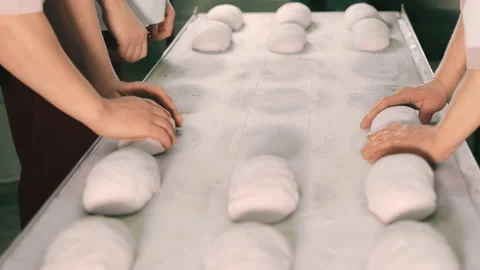 Bakers spread the dough in their hands for baking bread. Close-up of unfolding Stock Footage 237633271