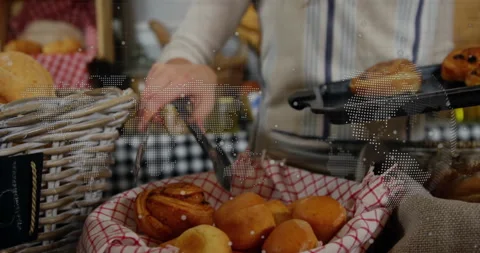 Bakery attendant picking up pastry from checkered basket, displaying world map 스톡 동영상 309097312