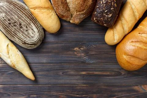 Bakery background, bread assortment on black wooden backdrop. Top view with.. Foto stock