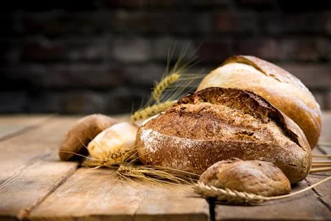 Bakery background. Set of freshly baked crispy bread and buns with ears of .. Stock Photos