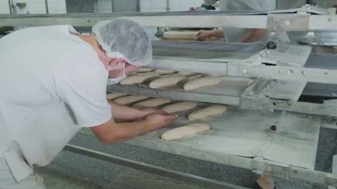 Bakery baking bakery. The worker makes patterns on the buns with a baking knife. Stock Footage 132783126