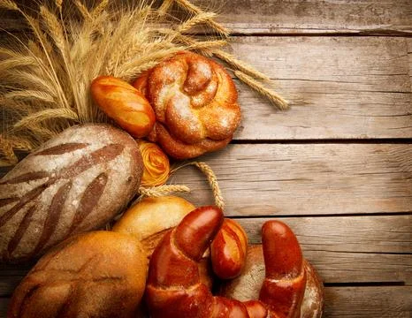 Bakery Bread and Sheaf over Wood Background Stock Photos