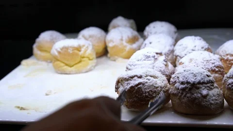 Bakery bread on the tray in the shop being picked by customer Stock Footage 98130185