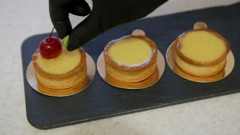 Bakery chef put cherry fruit on cake cream. Concept Bakery chef, Making cake Stock Footage 102368877