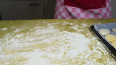 The bakery chef puts flour on the dough, the girl kneads the dough Stock Footage 169181917