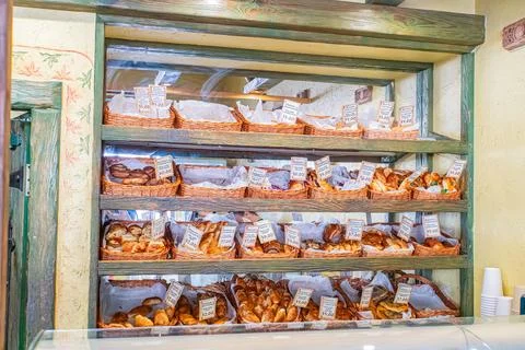 Bakery display filled with various bread and pastries, neatly arranged on m.. Stock Photos