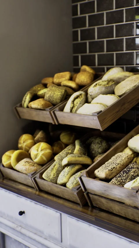 Bakery display shows various types of bread and rolls arranged on shelves Stock Footage 333566691