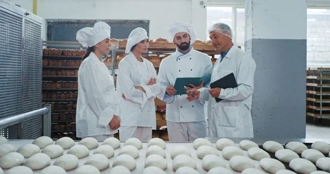 In a bakery factory two bakers chef one assistant listing concentrated their Stock Footage 112152050