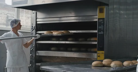 Bakery industry workers unloaded the cooked bread from the oven machine then Stock Footage 112143457