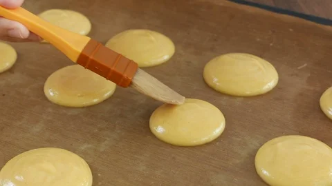 Bakery pastry chef brushing dough on baking paper. Stock Footage 86490110