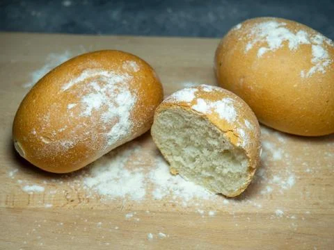 Bakery products. Table in the bakery. White bun on a cutting board. Product.. Stock Photos