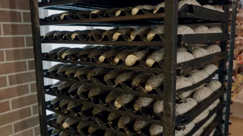 Bakery rack filled with freshly baked bread loaves, showcasing a variety of Stock Footage 340172353