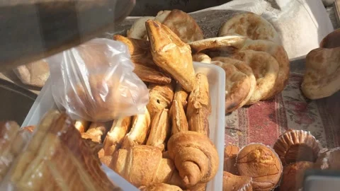 Bakery seller hands two large crispy croissants into bag for customer. Early mor Stock Footage 332876483