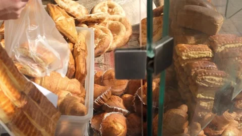 Bakery seller using metal serving tongs to place fresh pastries into bag for cus Stock Footage 332876211