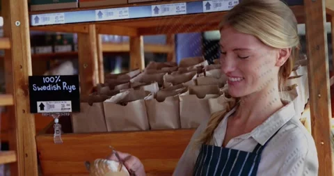Bakery worker bagging loaf with tongs for sale, patterned overlay appearing, Stock Footage 334111474