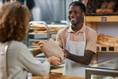 Bakery Worker Giving Package with Bread Stock Photos