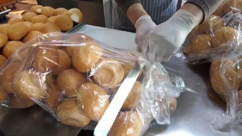 Bakery Worker Packing Fresh Bread Rolls in Plastic Bags Video stock 343587385