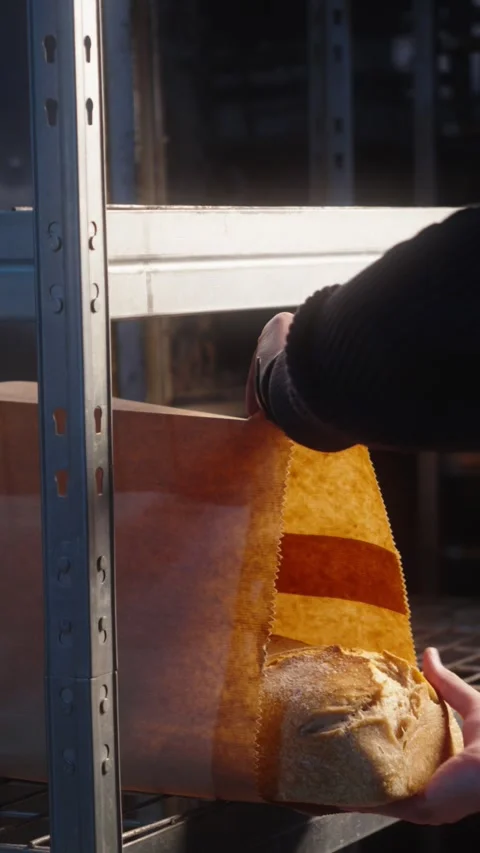 Bakery Worker Placing Fresh Bread into Protective Paper Packaging Stock Footage 345593177