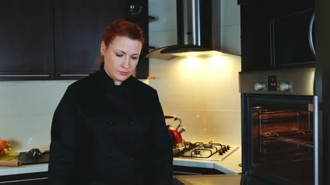 Bakery worker putting oven-tray with cookies to the oven Stock Footage 131530700