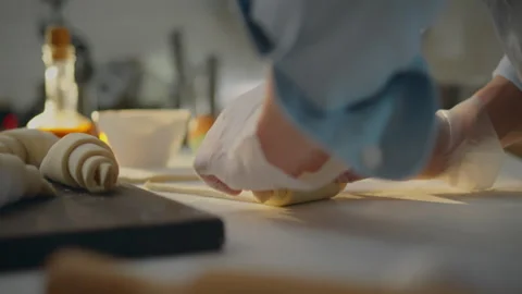 Bakery. A young chef dressed in comfortable work clothes prepares fresh croi Stock Footage 271155210