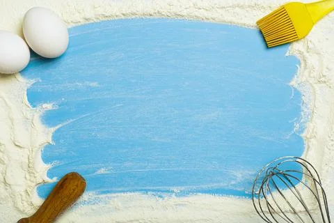 Baking and dough background. Wheat flour and kitchen items on a blue cooking Foto stock
