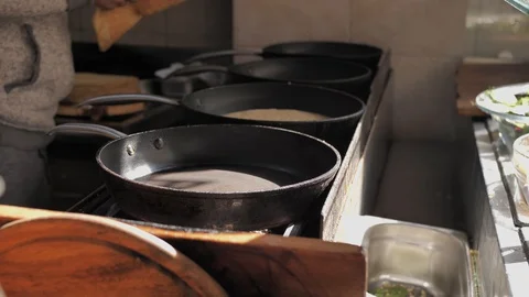 Baking and flipping a pancake on pan in sunlight at a street restaurant open air Video stock 127797133