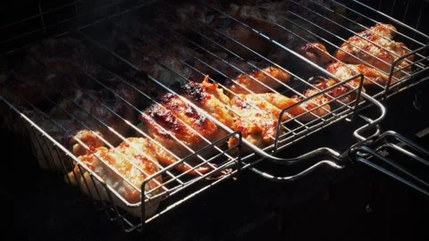 Baking and roasting marinated legs and wings chicken on barbecue grill. Stock Footage 169151632