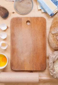 Baking background with cutting board, eggshell, flour, rolling pin Stock Photos